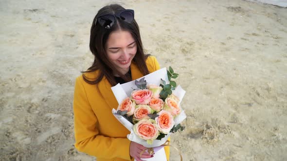 Girl Happily Dancing with Bouquet of Roses Bombastic in Yellow Coat, Close Up