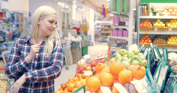 Woman Picking Out Fruit in Supermarket