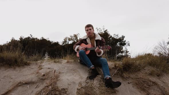 Boy Playing guitar on the beach