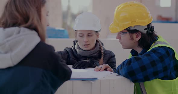 Engineer and Contractor Discussing Over Blueprint with Architect