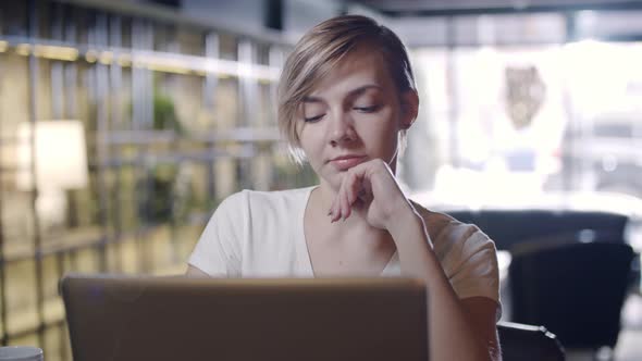 Woman Working on Laptop in Cafe