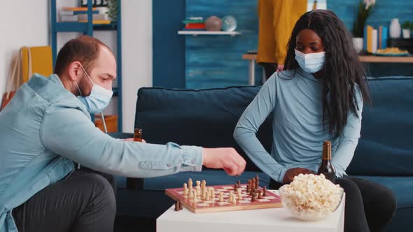 Cheerful Man Playing Chess with African Friend Wearing Face Mask