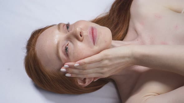 Woman After a Cosmetological Procedure Takes Off Her Glasses and Strokes Her Face