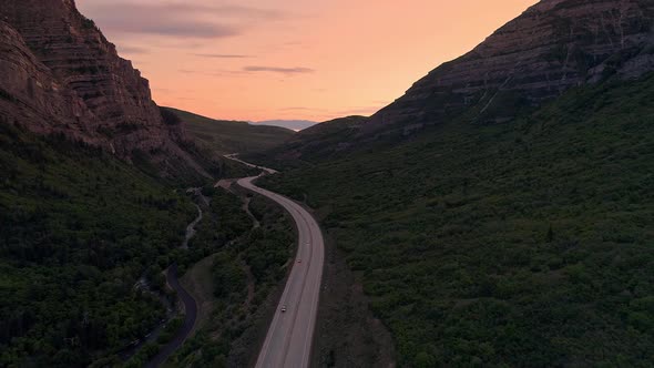 Flying through canyon with road winding through the landscape