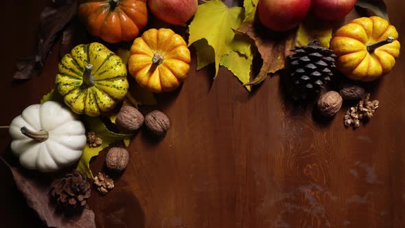 Decoration Made of Colorful Vegetables and Apples Lying on the Wooden Table Among Foliage and Cones