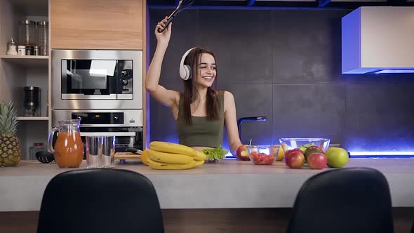 Funny Pretty Young Woman which Dancing Under Music in Her Headphones 