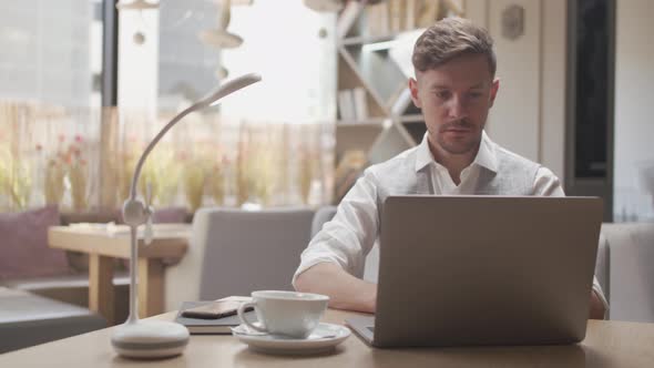 Businessman sitting and working in a cafe. Man using computer.