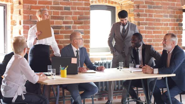 Diverse Old and Young Office Workers Gather Talking Discussing Online Project Laugh Working Together