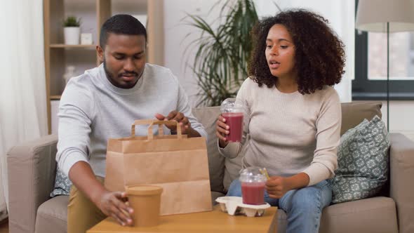 Couple with Takeaway Food and Straw Drinks at Home