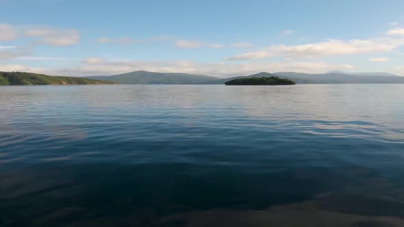 View from a boat on the driving towards a lone island. Marlborough Sounds. Near Picton, New Zealand.