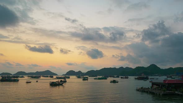 Vietnam Cat Ba bay at sunset with floating fishing boats on sea, cloudscape tropical weather, colorful sky and islands profile at the horizon