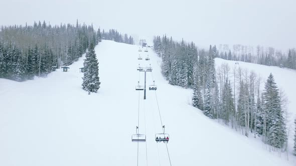 Aerial Footage of People Skiing on Steep Snowy Slopes of Mountain Resort