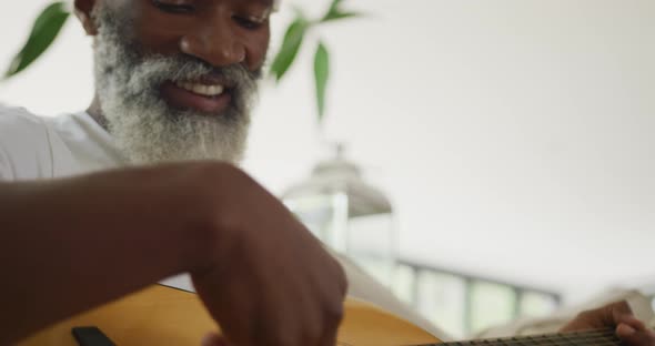 Video of sad african american senior man playing the guitar