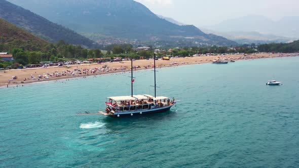 aerial drone circling a large boat along the Mediterranean coastline of Adrasan Beach in Turkey full