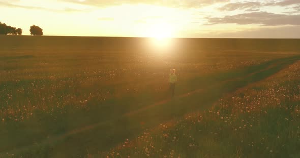 Sporty Child Runs Through a Green Wheat Field