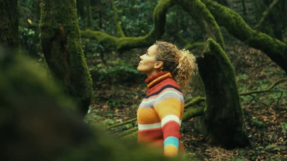 Overjoyed happy woman enjoying the green beautiful nature woods forest around her - female people