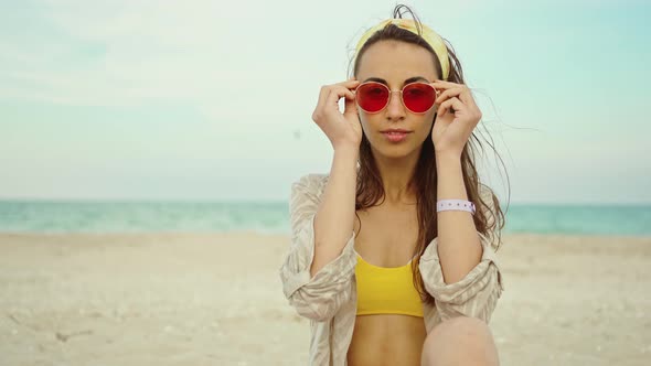 Closeup Outdoors Fashion Portrait Young Woman Wearing Yellow Bikini and Pink Sunglasses By Sea on