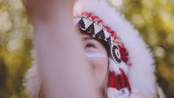 Woman In Headdress Smiling And Looking Up At Horse