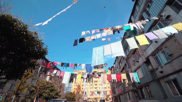 Laundry is hanging on a rope in the courtyard of an old multi-storey building.