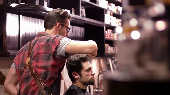 Hairdresser combing clients hair