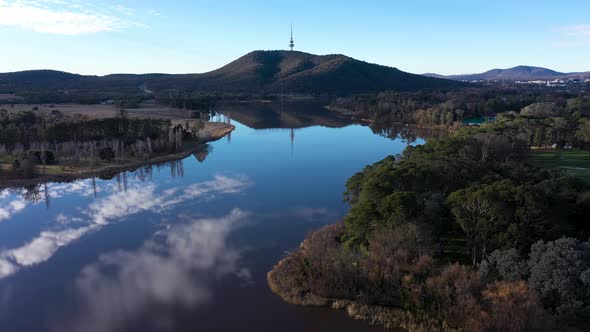 Stunning Canberra Lake Burley Griffin aerialing forward, with cloud and Telstra Tower reflection in