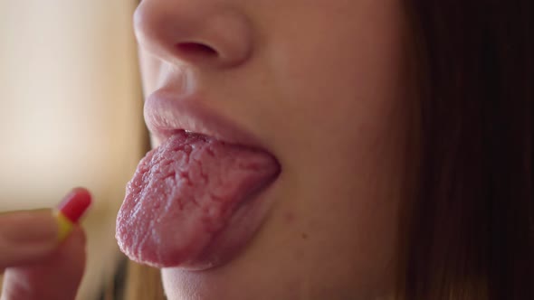 Close-up View of Female Hand Putting Pill on Her Tongue. Troubled Teens. Drug Addiction