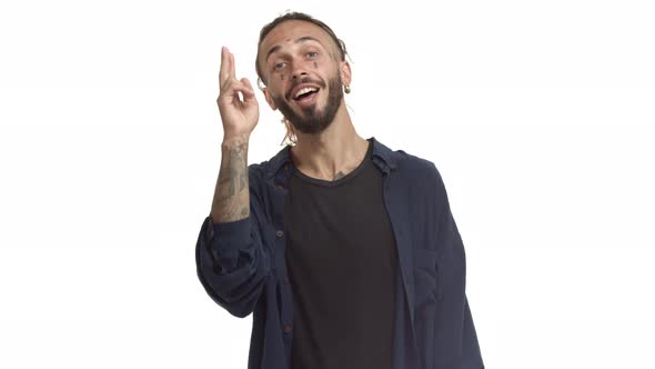 Attractive Bearded Man with Tattoos on Face and Body Saluting you Greeting Someone and Nodding