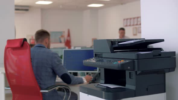 Senior manager sits at the workplace in the office and prints important documents