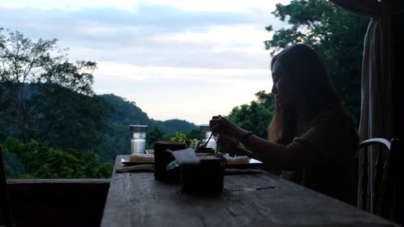 Blurred of a woman having dinner and looking a beautiful nature view