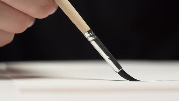 Drawing a Straight Line with a Paint Brush on a White Sheet of Paper Artist Hand Painting Graphic