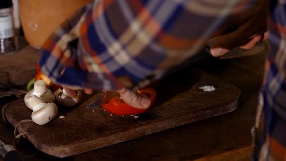 Man chopping a vegetables on chopping board in kitchen