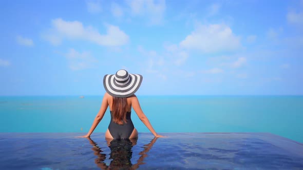 Young asian woman enjoy around outdoor swimming pool for leisure