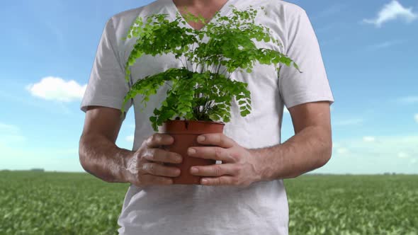 Man in field holding plant