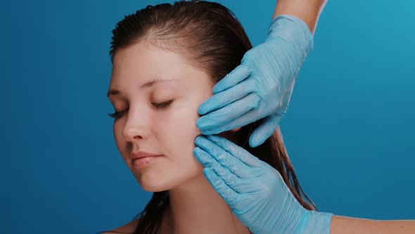 Woman Without Make-up with Wet Fresh Hair Receiving Massage By Therapist in Blue Gloves