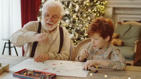 Boy and Grandfather Drawing Christmas Tree Together