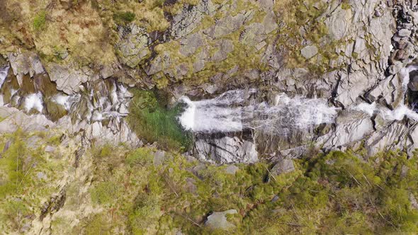 Aerial View of Waterfall Flowing Trough Rocks of Mountain