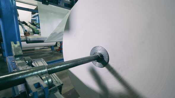 Industrial Mechanism with a Massive Roll of Paper Spinning on It