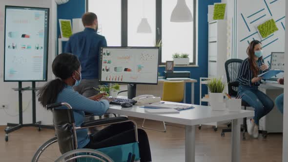 Paralysed Black Worker and Employee with Protective Mask Working Together