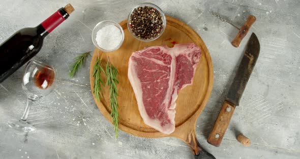 The Steak T-bone Raw Beef on the Cutting Board Rotates 