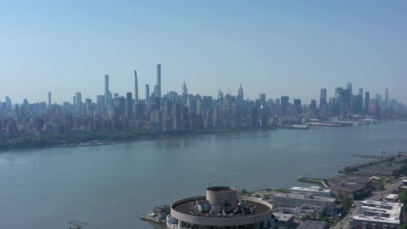 A drone view of the Hudson River in NY, looking south on a sunny day. The camera pan left over an ap