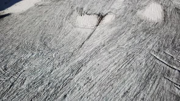 Drone view, tilt up, a glacier with dark crevices in the middle of high mountains, Cabane d'Orny