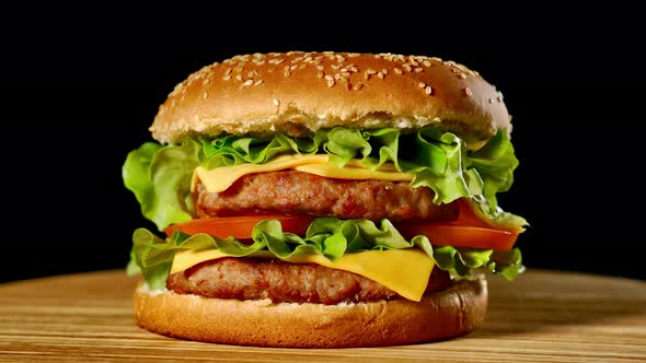 Fresh Appetizing Hamburger Rotating on Black Background. Seamless Loopable Shot, .