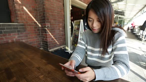 Woman using smartphone in cafe 