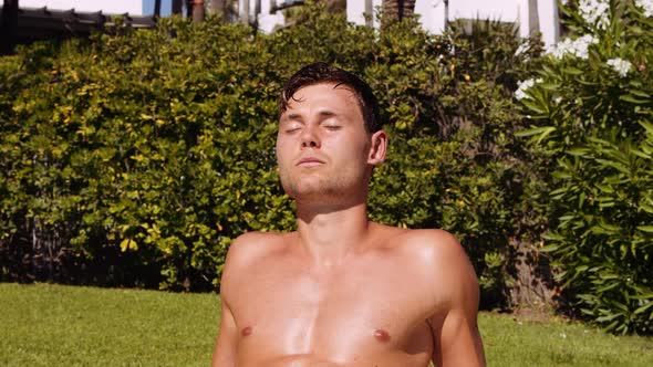 Young Man Sunbathing With Eyes Closed