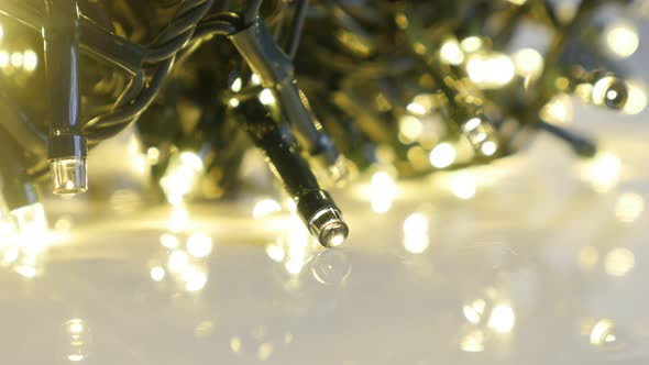 Close-up sequence of shiny fairy lights 4K 2160p 30fps UltraHD footage - Christmas decoration on whi