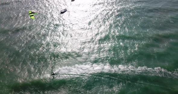 Aerial drone view of a man kiteboarding on a kite board