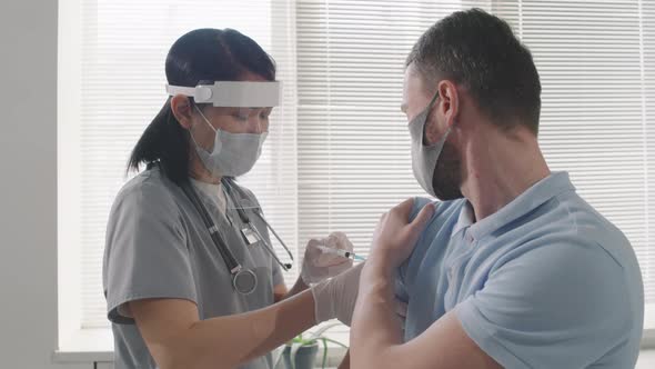 Nurse Giving Vaccination Dose To Patient