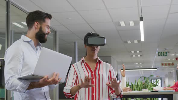 Happy diverse male and female business colleagues using vr headset in office