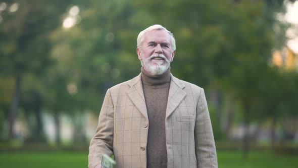 Happy Old Man Holding Dollar Bills in Hand, Retirement Savings, Pension Fund