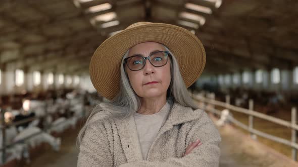 Senior Woman with Crossed Arms Standing at Goat Farm